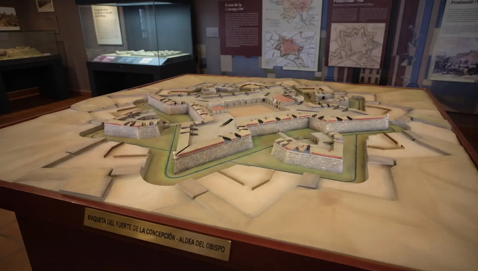 Vista detallada de la maqueta del Fuerte de la Concepción en Aldea del Obispo, Salamanca, expuesta en el museo local, con paneles informativos al fondo.